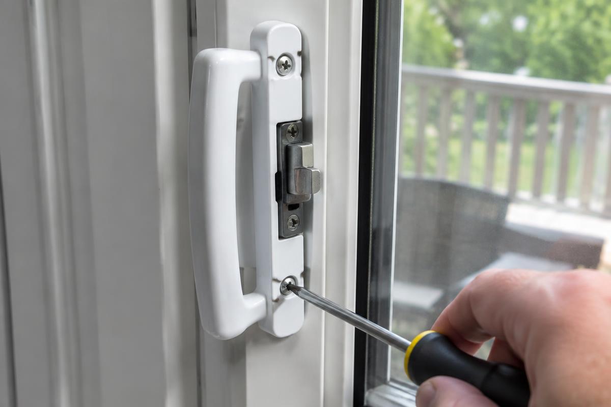 Sliding glass door handle and latch being fastened with a screwdriver